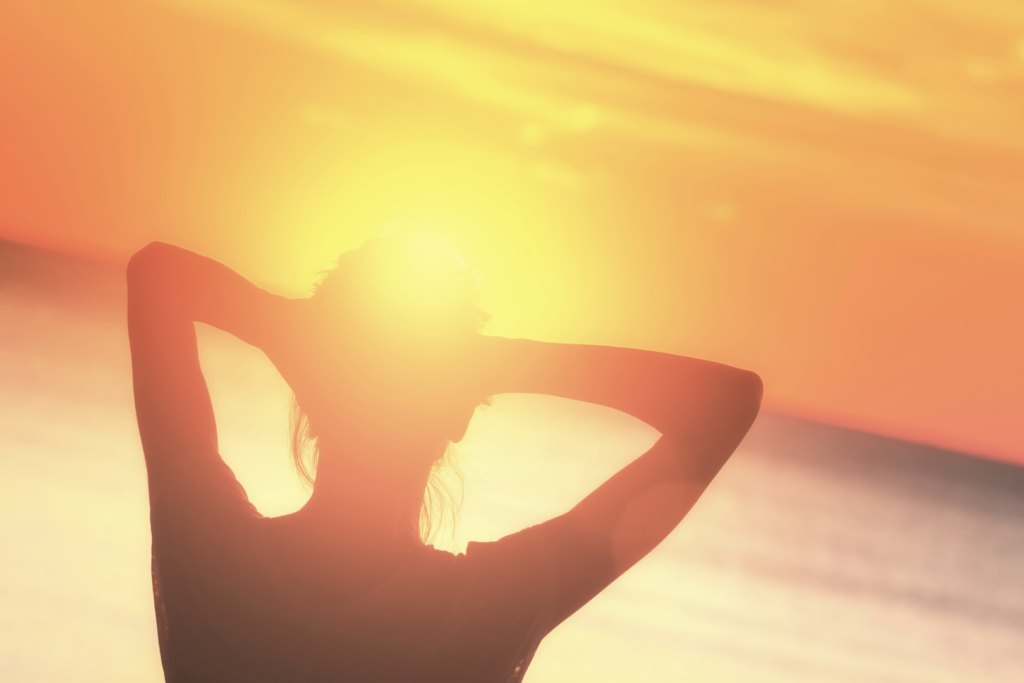 Image of woman watching the sunset for "Which triggered the thought that most of us grew up with the notion that in order to “be healthy” we needed to workout for longer periods of time and put loads of stress on ourselves in order to see results." Blog Post