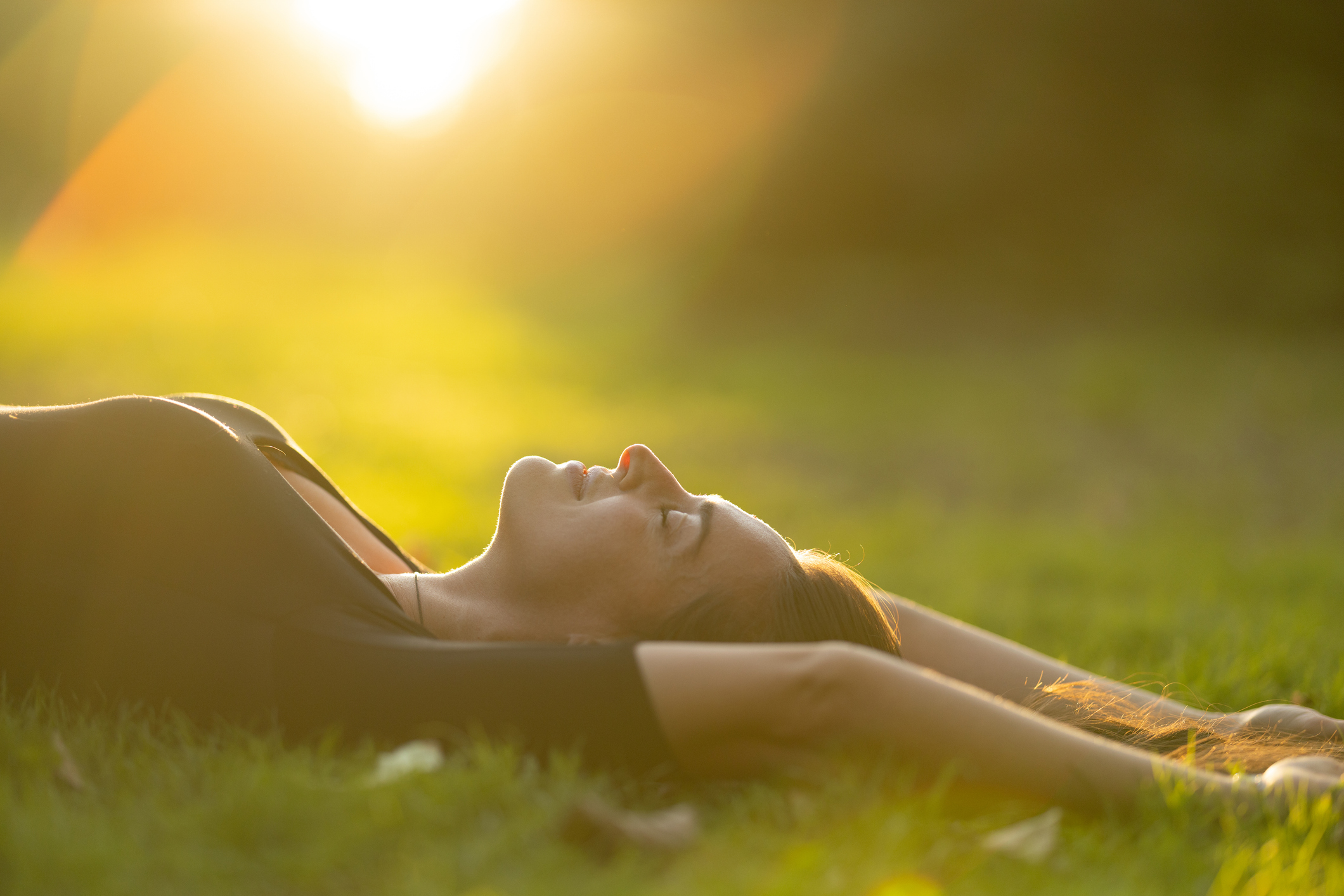Woman laying in the grass in the sun